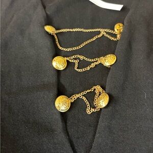 ASOS black dress with gold chains draping the chest area.